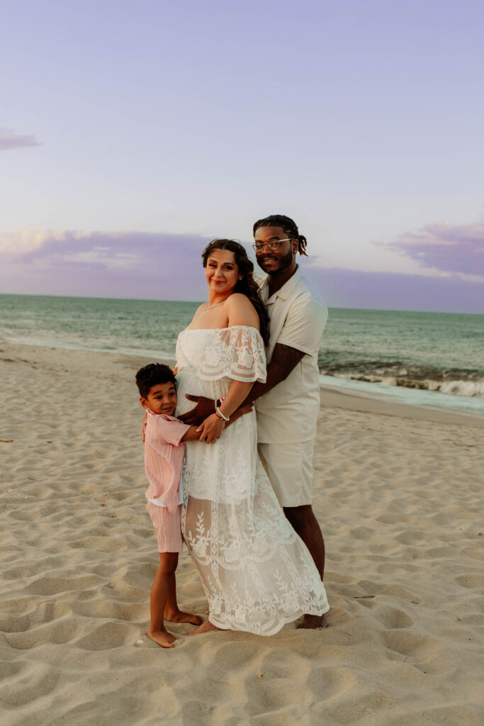 A family posing for a family photo at Sandy Hook Beach in New Jersey. 