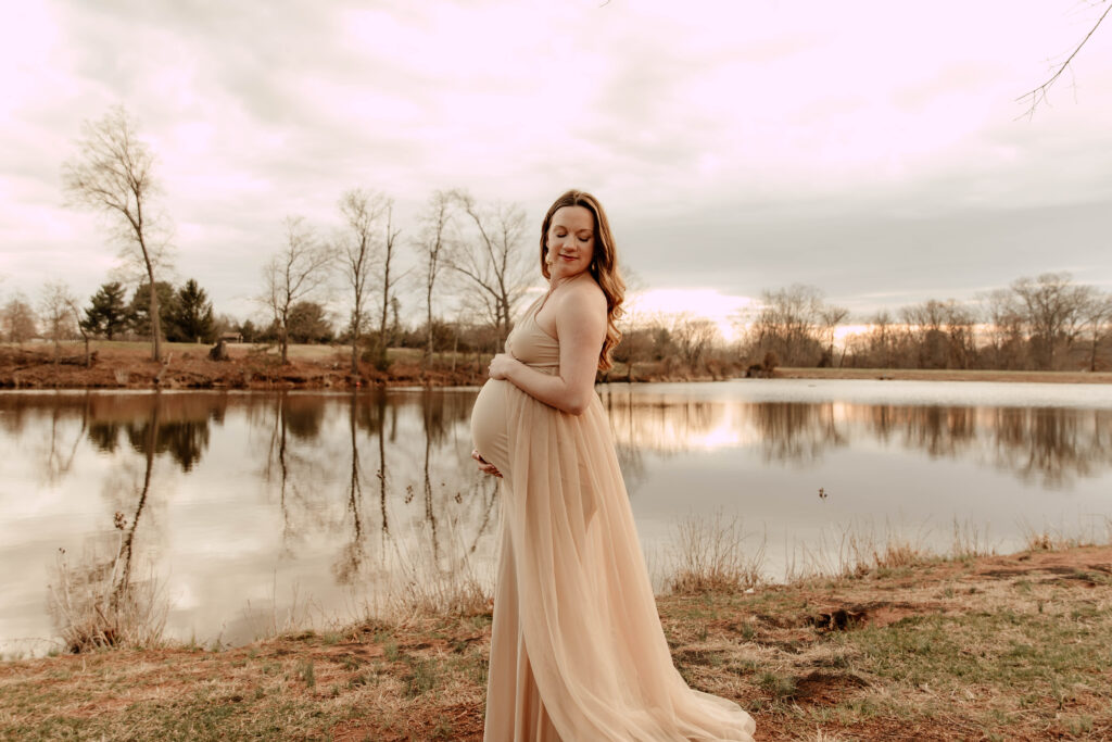 A pregnant woman posing for a phot in front of a lake at Colonial Park in Somerset, New Jersey. 