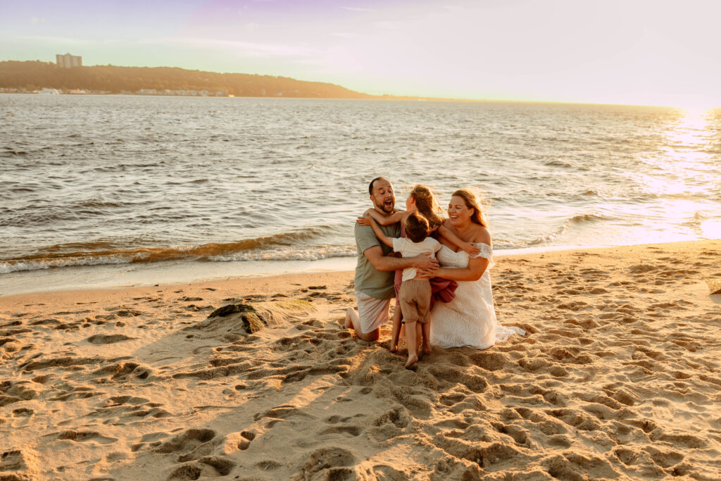 A family giving a giant hug on the beach at Sandy Hook, NJ.