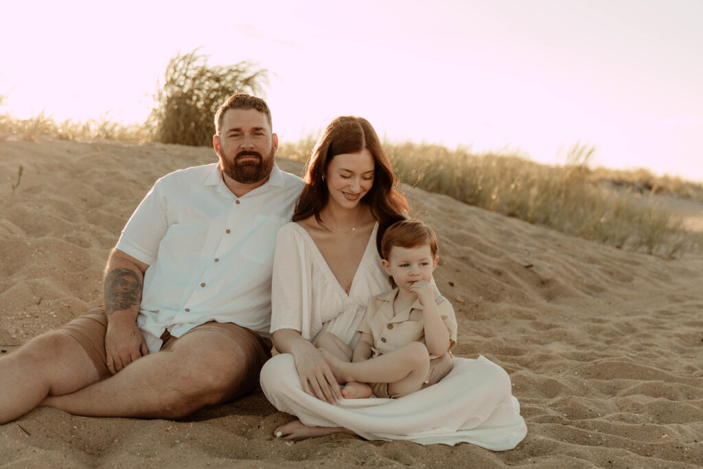 a family sitting on the beach at Sandy Hook , NJ