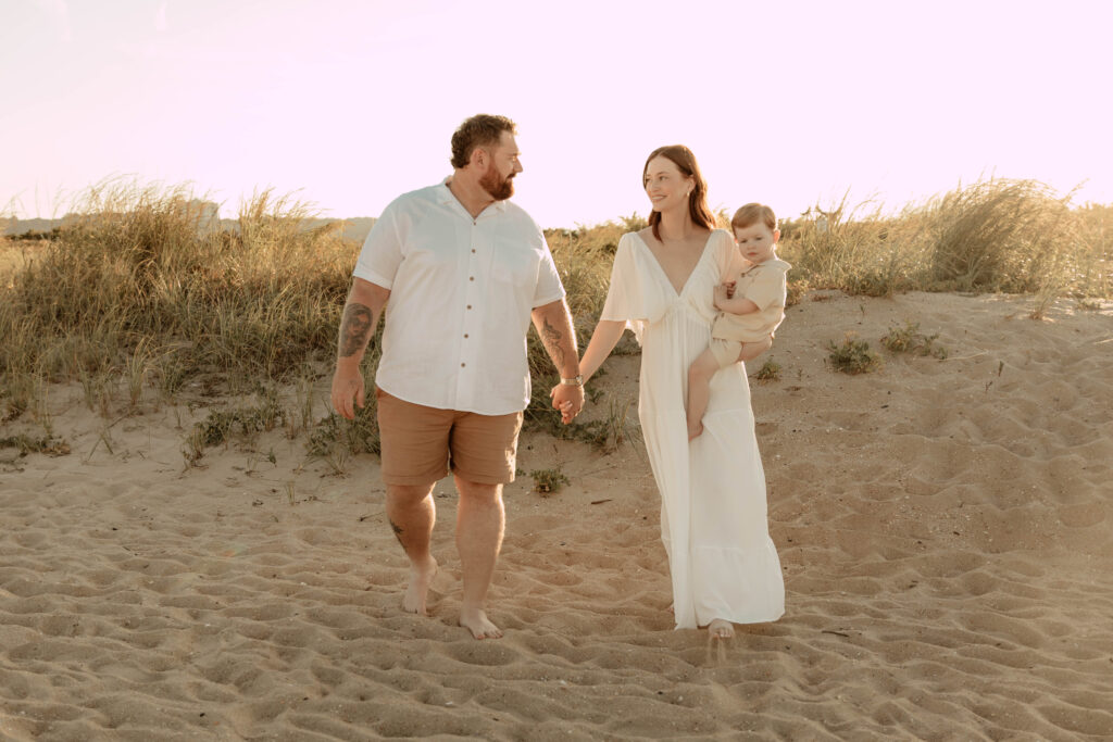 a family walking hand in hand on a beach in Monmouth County, New Jersey