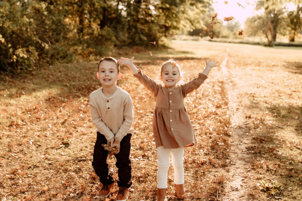 2 kids throwing leaves in the air during a New Jersey photoshoot
