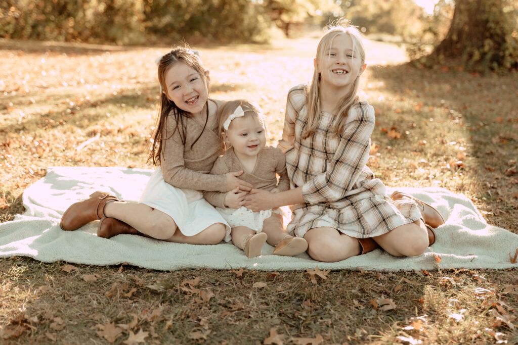 siblings sitting on a blanket posing during a fall family session in New Jersey