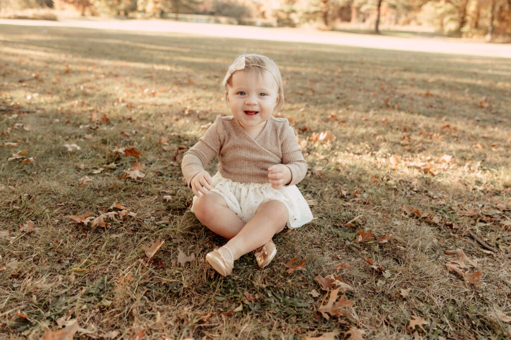 a small child posing for a fall photo in Oak Ridge Park, Clark, New Jersey. 