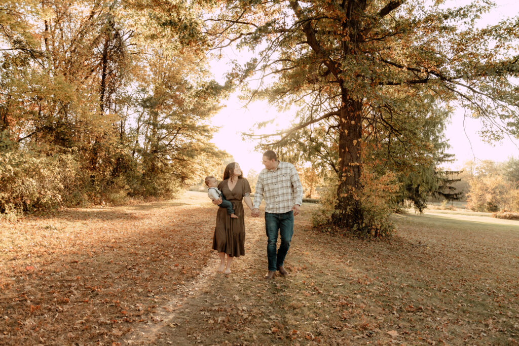 A family walking during a fall photo session in Oak Ridge Park in Clark, New Jersey. 