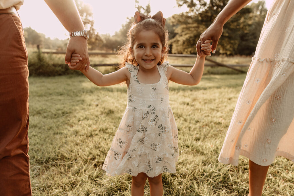 a girl smiling with her parents at Lenape Park in Cranford, New Jersey