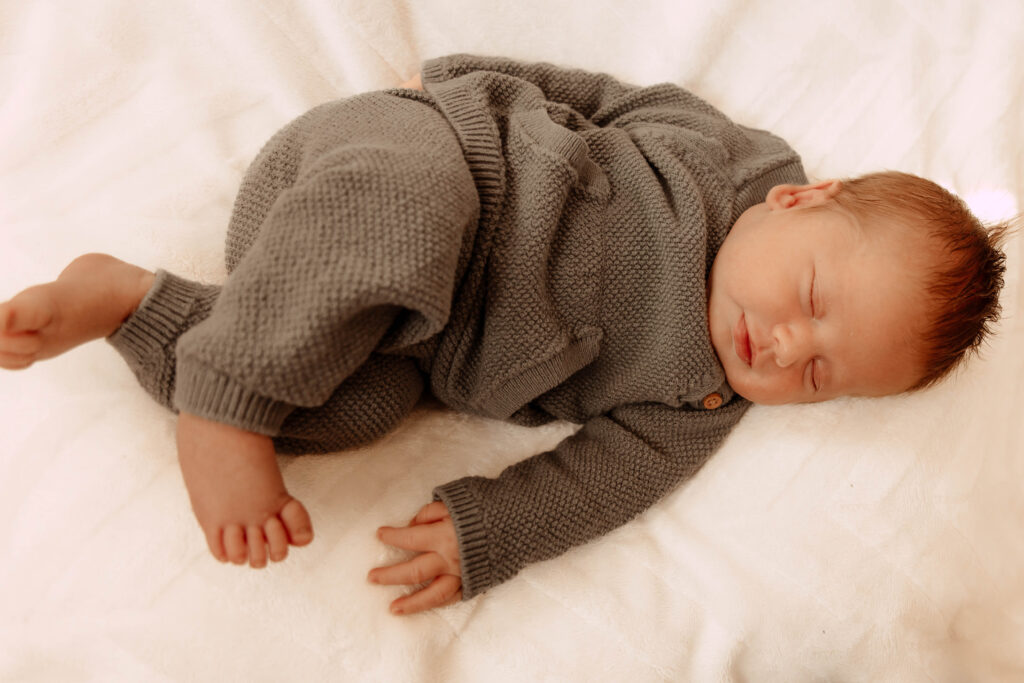 a newborn boy posing for a newborn photo in a home in New Jersey
