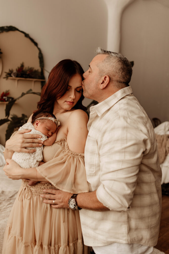a photo of a mom and dad holding a baby during an in-home newborn session in New Jersey 