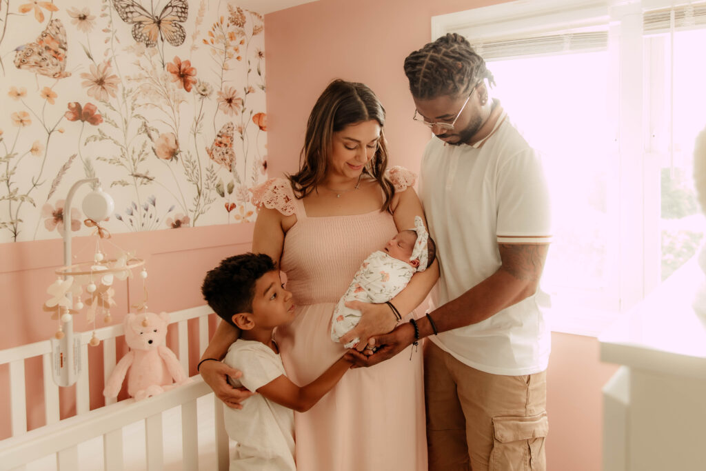 a family holding a newborn during an in-home newborn session in New Jersey.